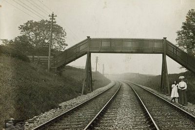 Passengers at Livingston station awaiting a train by the foot bridge over the tracks